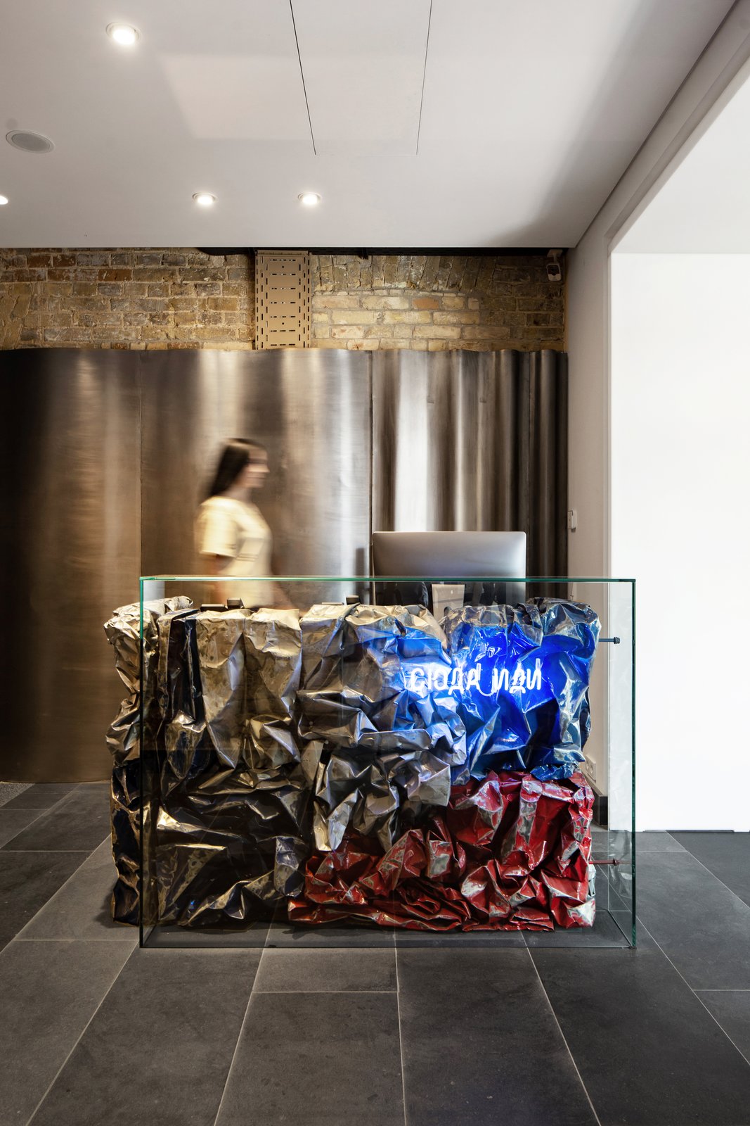 Bursa's reception desk is composed of scrunched-up metal sheets set behind a glass panel.